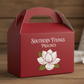 red gable box with SOUTHERN FIXINGS PRALINES in white with a magnolia flower on the front